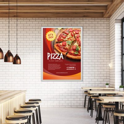 Pizza Poster Template hanging in a snap poster frame on a white subway tile wall in a pizzaria