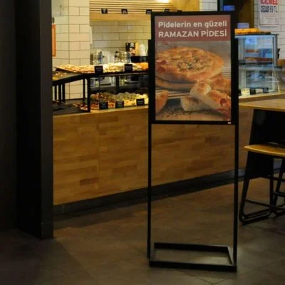Single Tiered Eco Poster Display Stand in front of a small cafe