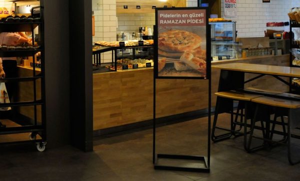 Single Tiered Eco Poster Display Stand in front of a small cafe