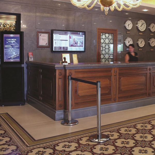 Black Retractable stanchion in front of a check in desk at a hotel