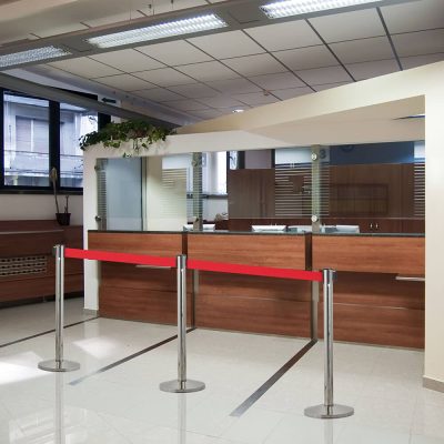 Red Retractable Stanchion in front of a check in desk