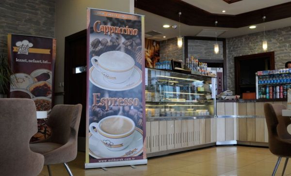 Large Smart Roll Banner that is advertising coffee in a small dining hall