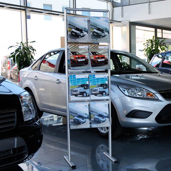 A standing brochure rack with car adverts in a car dealership