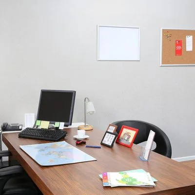 Desk with Computer, papers and frames on it.