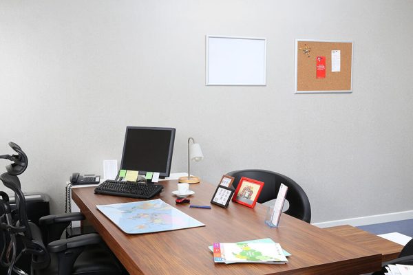 Desk with Computer, papers and frames on it.