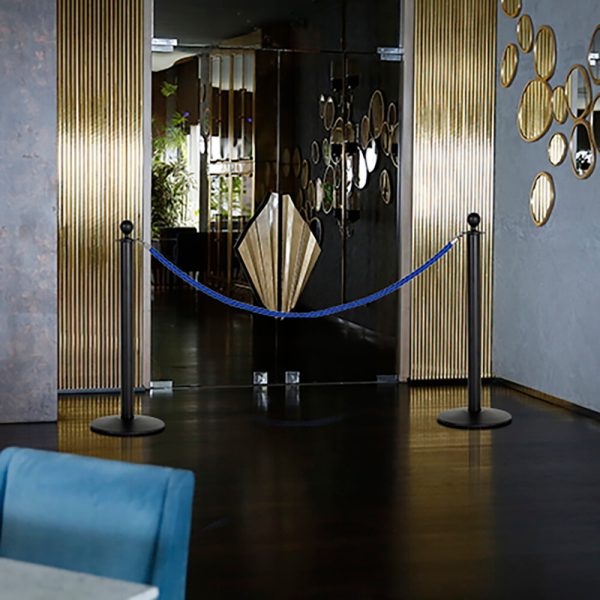 Stanchion with Blue Rope blocking off a set of doors with gold embellishments