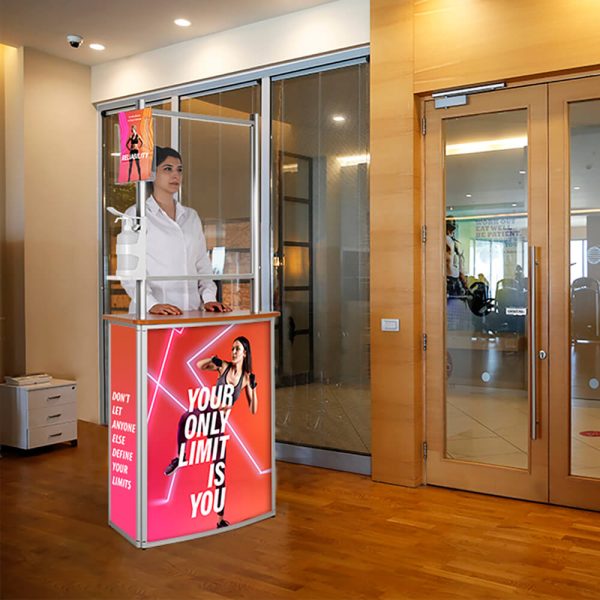 Woman standing behind a pop up display with a brochure holder hanging from it