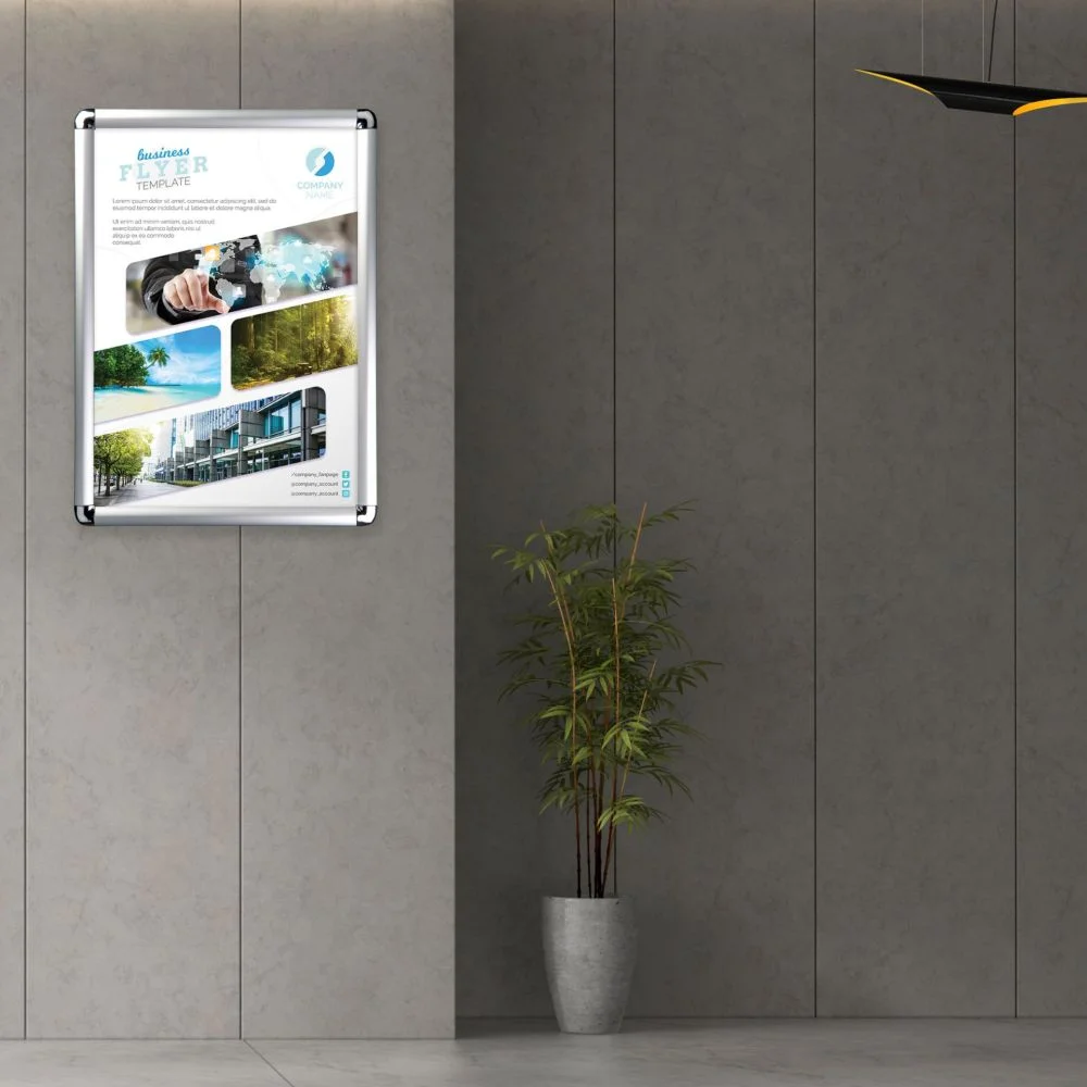 Snap Frames 25 mm A3 round A rounded corner silver snap frame holding a flyer in the hallway of an office building