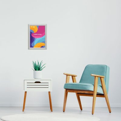 Small colorful poster hanging in a snap frame above a lounge area with a chair & a side table
