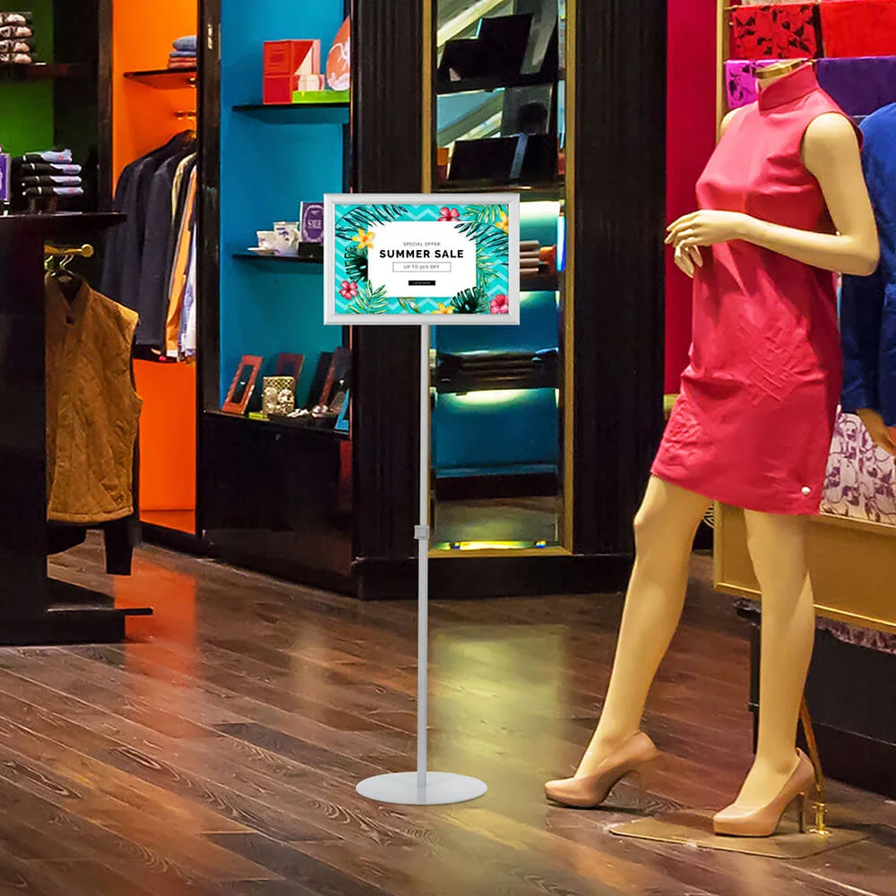 floor-sign-stand-holder-with Landscape Adjustable Floor sign stand holder in a clothing store advertising a sale that is taking place