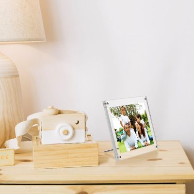 Side table in a kids room with a wooden camera and family photo on it