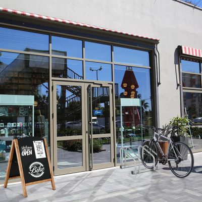 Timber Chalk Board outside of a bike shop that has the hours of the shop on it