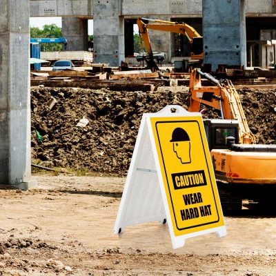 Caution Wear Hard Hat on a white SignPro Sidewalk Sign in a construction zone