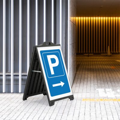 Parking here poster on a Black A-Board SignPro Sidewalk Sign on the sidewalk outside of a parking garage