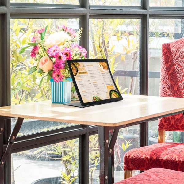 an Arc Desktop Menu holder next to a bouquet of flowers in a small cafe