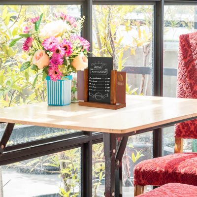 Desk top menu holder next to a bouquet of flowers in a small cafe