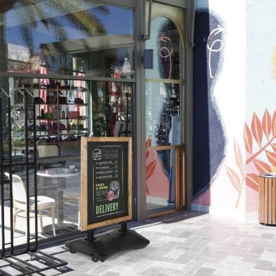 WindPro Pavement Sidewalk Sign with magnetic Chalkboard outside of a cafe