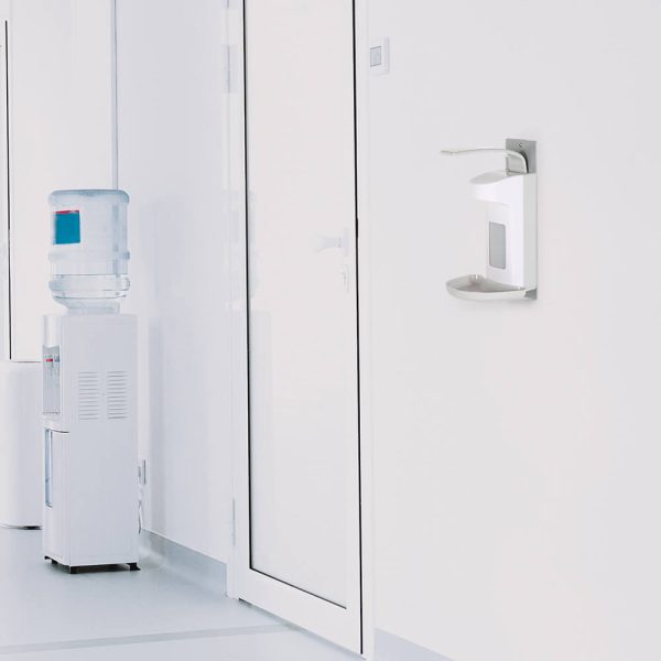 Hand Sanitizer or Soap Dispenser hanging on the wall in an office next to a water cooler