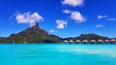 bora bora in french polynesia, with tiki huts in the background