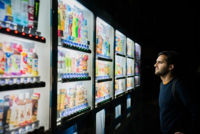 man looking at vending machines