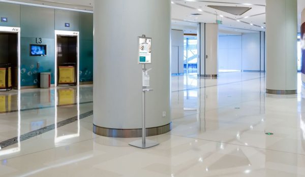 a floor standing hand sanitizer dispenser in a shopping center