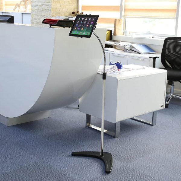 a floor standing tablet stand next to a check in desk at an office building