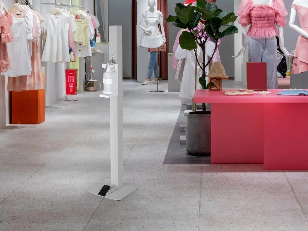 White basic touchless hand sanitizer dispenser in a small boutique