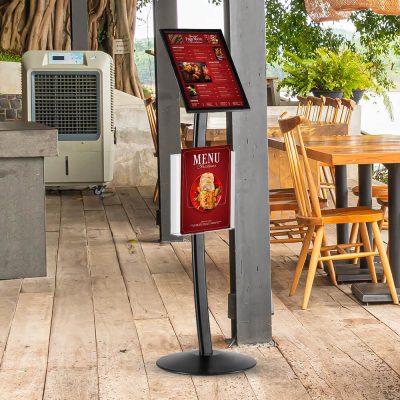 A floor standing menu board in the outside seating section of a restaurant