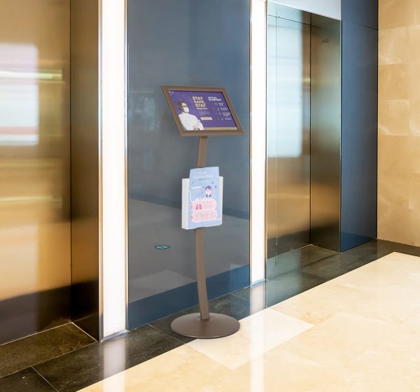 Pedestal sign holder between two elevators