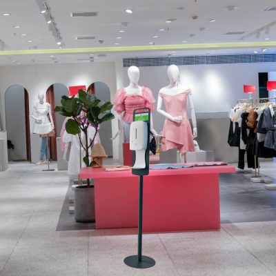 Floor Standing Automatic Touch Free Sensor Liquid Hand Sanitizer Dispenser with Dip Tray in a clothing boutique