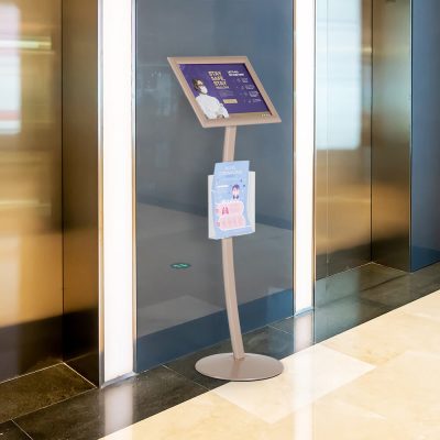 Pedestal sign holder between two elevators