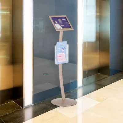 Pedestal sign holder between two elevators