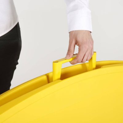 a woman carrying the yellow sidewalk sign holder