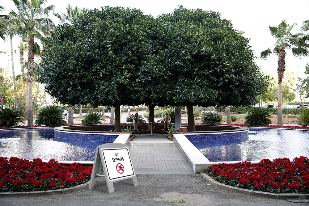 sandwich-board-a-frame-double-sided No swimming sign on a gray sandwich board in front of a fountain