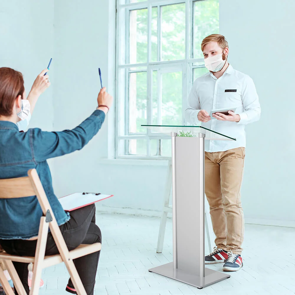 tempered-clear-glass-podium Man giving a presentation from a podium to a group of eager peers