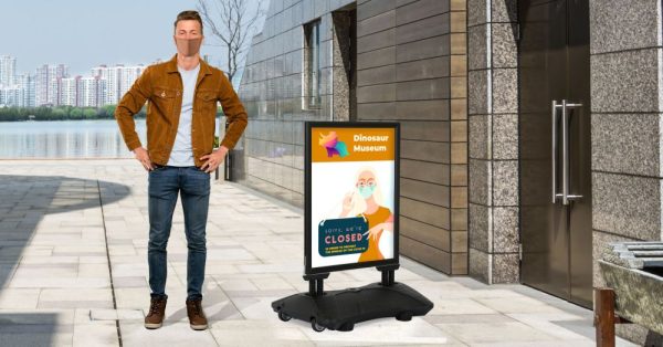 Man Standing next to the WindPro Lite Water Base Weather Resistant Sidewalk Sign Holder