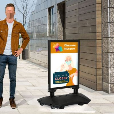 man standing next to a WindPro Weather resistant outdoor sidewalk sign