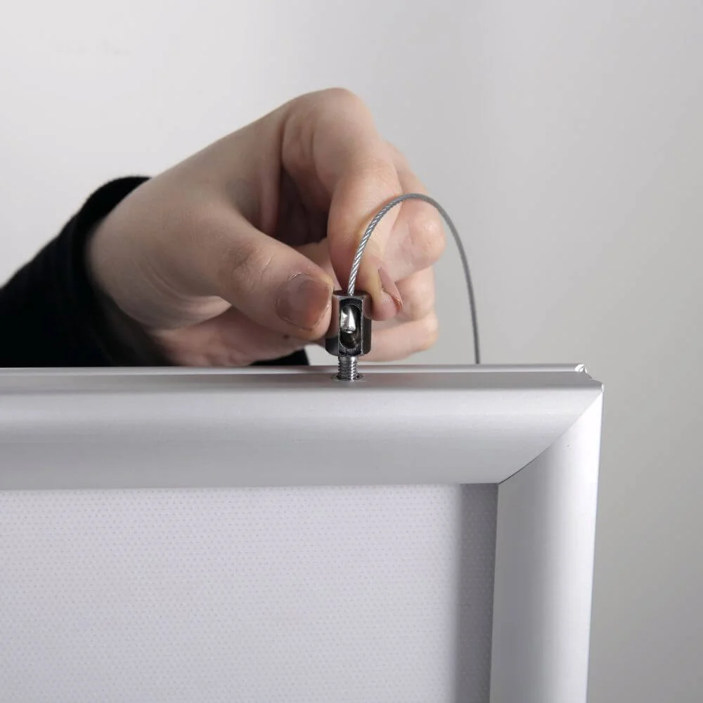 a person showing how the hanger part of the LED Snap Poster frame is attached
