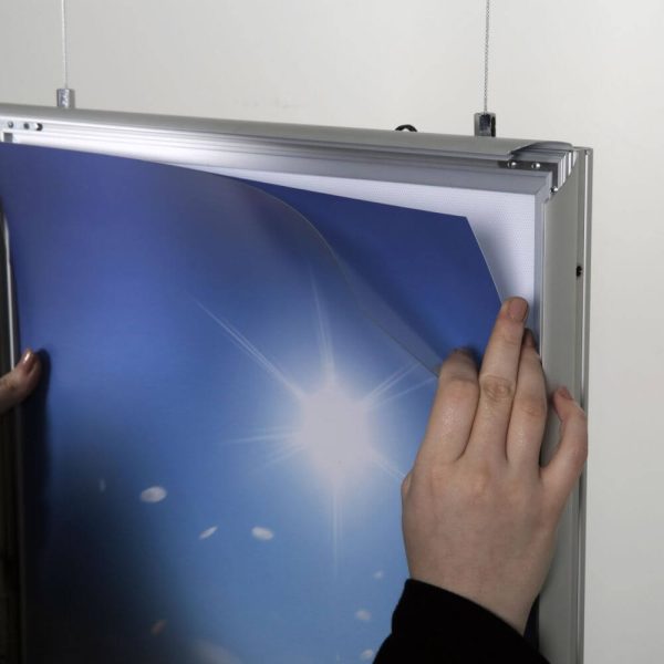 A worker switching out the poster in the LED Light Snap Poster Frame