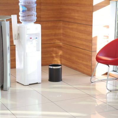 A lounge area with a water cooler and the Black Open top waste basket